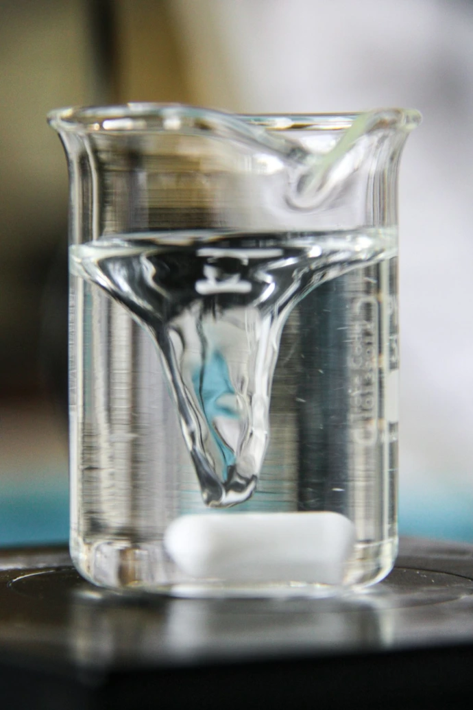 A tablet dissolves in water within a beaker.